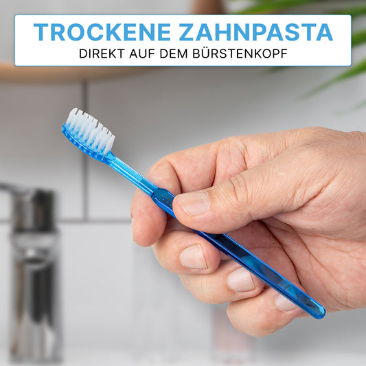 Eine Hand hält eine ARNOMED Einweg Zahnbürste mit Zahnpasta von ARNOWA GmbH. Deutscher Text: "Trockene Zahnpasta direkt auf dem Bürstenkopf" betont die bequeme, schnelle Anwendung unterwegs. Box enthält 100 Stück.
