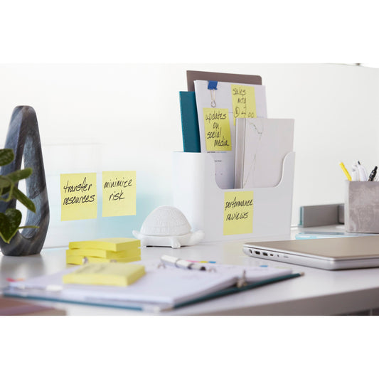 Auf einem weißen Schreibtisch mit Büromaterial und einer weißen Ordnerablage sind Post-it® Super Sticky Z-Notes (Gelb, 76x127mm, 90 Blatt/Block, 12 Blöcke/Packung) der 3M Deutschland GmbH für Aufgaben beschriftet, daneben eine kleine weiße Schildkrötenfigur.