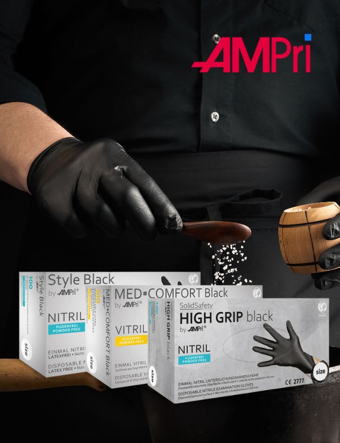 Werbung für AMPri Einmalhandschuhe. Eine Person in schwarzer Kleidung streut mit einer Hand, die in einem schwarzen Nitrilhandschuh steckt, grobes Salz aus einem Holzlöffel. Rechts ist eine Holzgewürzmühle zu sehen. Im unteren Bereich sind drei Produktverpackungen abgebildet: Style Black, MED-COMFORT Black und SolidSafety HIGH GRIP black – allesamt puderfreie Einmalhandschuhe aus Nitril oder Vinyl. Oben rechts prangt das rot-blaue AMPri-Logo.
