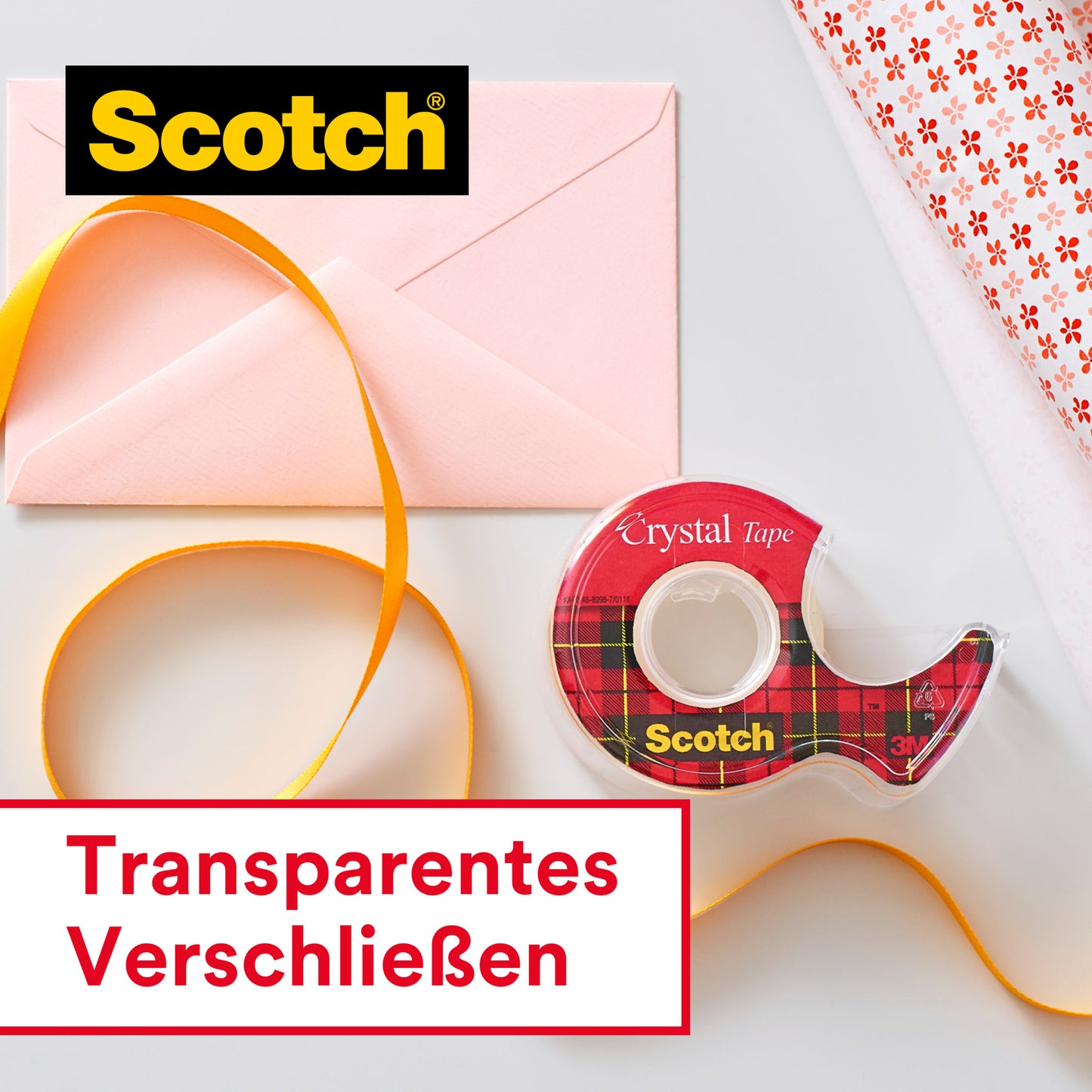 Eine Rolle Scotch® Crystal Klebeband, 19 mm x 15 m mit Handabroller der 3M Deutschland GmbH, ein rosafarbener Umschlag, gelbes Band und gemustertes Geschenkpapier sind auf einer weißen Fläche angeordnet. Auf dem Etikett steht "Transparentes Verschließen.