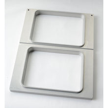 Η κασέτα Duni GmbH DF15/25 για δίσκους CPET 960-1500 ml - 2 χρήσεων είναι ένα ορθογώνιο μεταλλικό πλαίσιο με δύο κάθετα τοποθετημένα ανοίγματα, βουρτσισμένο φινίρισμα και στρογγυλεμένες άκρες - ιδανικό για την αποθήκευση δίσκων CPET σε οποιαδήποτε λευκή επιφάνεια.