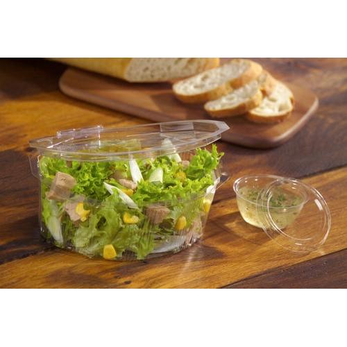 Ένα καθαρό, στρογγυλό καπάκι Starpak 100 (PS, Ø 6,7 cm, ύψος 1 cm) κλείνει ένα πλαστικό δοχείο με πράσινη σαλάτα, καλαμπόκι και κρέας, ενώ στο φόντο υπάρχει κομμένη μπαγκέτα πάνω σε ξύλινη σανίδα.