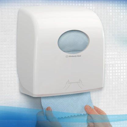 Ένας λευκός διανομέας της Kimberly-Clark GmbH για Scott® Essential™ Slimroll™ πετσέτες χεριών (190,00 μ x 19,80 εκ) είναι τοποθετημένος στον τοίχο, με ένα χέρι που τραβάει μια μπλε πετσέτα, ορατό στο στρογγυλό παράθυρο για φιλική προς το περιβάλλον ξήρανση χεριών.
