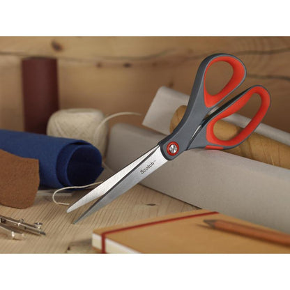 Το κόκκινο ψαλίδι ακρίβειας Scotch™ από την 3M Deutschland GmbH με γκρι και κόκκινη λαβή βρίσκεται σε ξύλινη επιφάνεια ανάμεσα σε ρολά υφάσματος, μια σπείρα με λευκή κλωστή, ένα καφέ σημειωματάριο και ένα μολύβι.