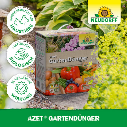 Eine Kiste mit Neudorff Shop Azet GartenDünger steht auf einem Gartenweg inmitten üppiger Pflanzen und zeigt Bilder von Gemüse, Obst und Symbole für die Sicherheit von Haustieren, biologische Herkunft und zuverlässige Wirksamkeit.