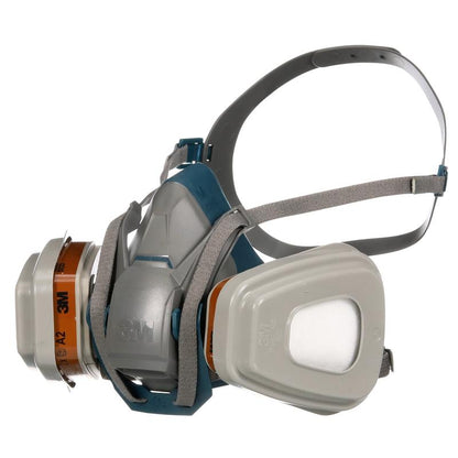 Η 3M™ Quick Latch αναπνευστική μάσκα 6502QLKIT-1 από την 3M Deutschland GmbH με ανταλλάξιμα φίλτρα A2P3 (1x6502, 2x6055, 2x5935, 2x501) δείχνει ρυθμιζόμενους γκρι ιμάντες και ένα γκρι-μπλε περίβλημα μάσκας με εμφανές λογότυπο.