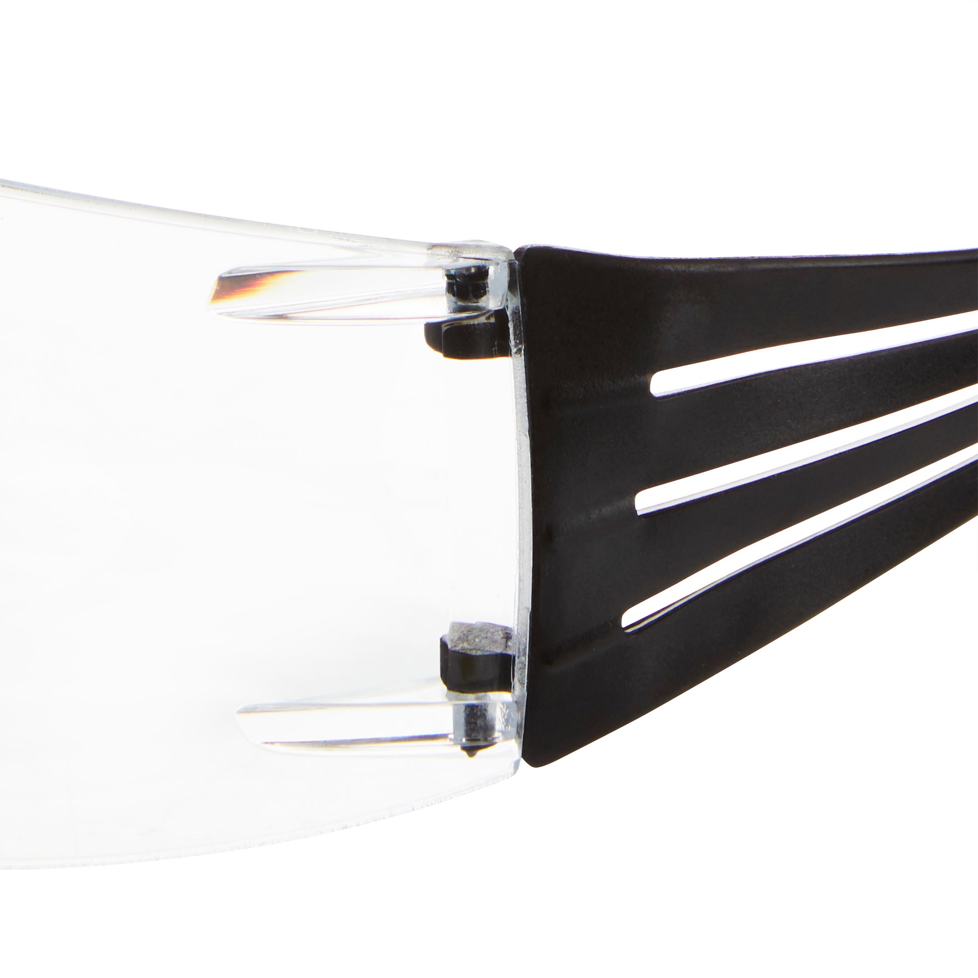 Nahaufnahme des Scharnierbereichs, in dem eine klare Kunststofflinse auf einen schwarzen Arm der 3M™ SecureFit™ Lese-Schutzbrille der 3M Deutschland GmbH trifft, mit Hervorhebung von Verbindungs- und Designdetails.