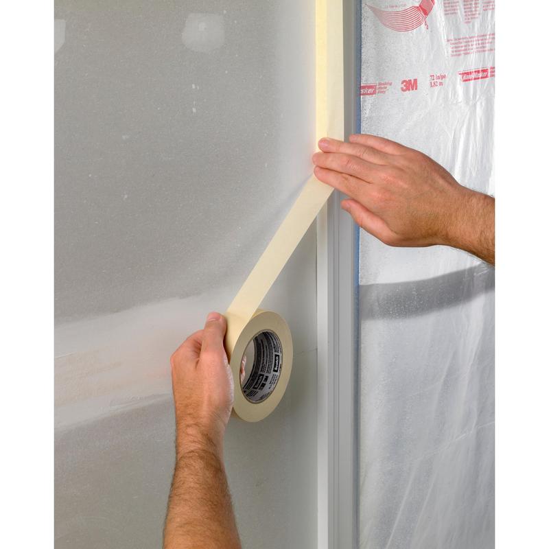 Ένα άτομο κολλάει ταινία κάλυψης Scotch® Basic, 50 μ από την 3M Deutschland GmbH κατά μήκος της άκρης ενός πλαισίου παραθύρου με πλαστική επένδυση, πιθανώς ως προετοιμασία για βαφές ή οικοδομικές εργασίες.