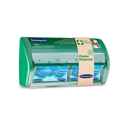 Ένας διανομέας επιδέσμων Salvequick από την Orkla Wound Care AB έχει διαφανή μπροστινή πλευρά και διανέμει μπλε, ανιχνεύσιμους επιδέσμους· μια καφέ χαρτονένια ταινία τον χαρακτηρίζει ως διανομέα επιδέσμων".
