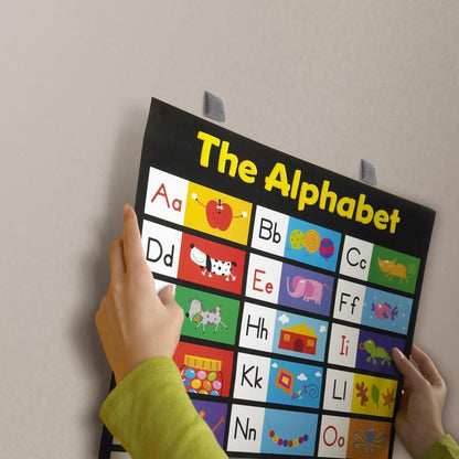 Ένα άτομο δείχνει έναν ζωντανό πίνακα αλφαβήτου με γράμματα εικόνας, που είναι προσωρινά στερεωμένος σε λείο τοίχο με τα αφαιρούμενα τετράγωνα στήριξης Scotch-FIX™ 108-ST64-P, 12,7 mm x 12,7 mm, της 3M Deutschland GmbH, και μπορούν να αφαιρεθούν εύκολα. Η συσκευασία περιέχει 64 τεμάχια.