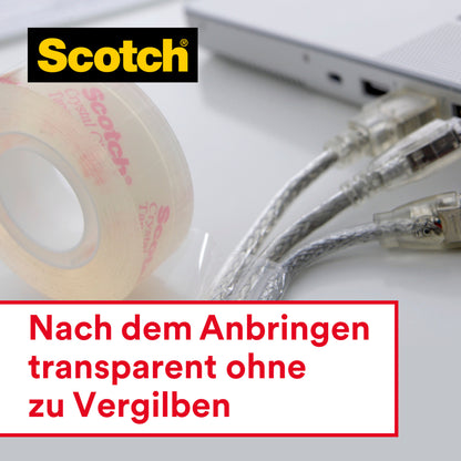 Eine Rolle Scotch® Crystal Klebeband (19 mm x 7,5 m) mit Handabroller von 3M Deutschland GmbH liegt neben einem Laptop und Kabeln. Text im Bild: "Nach dem Anbringen transparent ohne zu Vergilben.