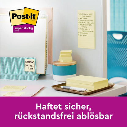 Μια στοίβα Post-it® Super Sticky Notes, Κίτρινο, 76 mm x 127 mm, από την 3M Deutschland GmbH, με μερικές σημειώσεις σε έναν λευκό τοίχο σε ένα οργανωμένο γραφείο. Το κείμενο λέει: "Κολλάει με ασφάλεια, αφαιρείται χωρίς υπολείμματα." 100% πιστοποιημένο με PEFC.