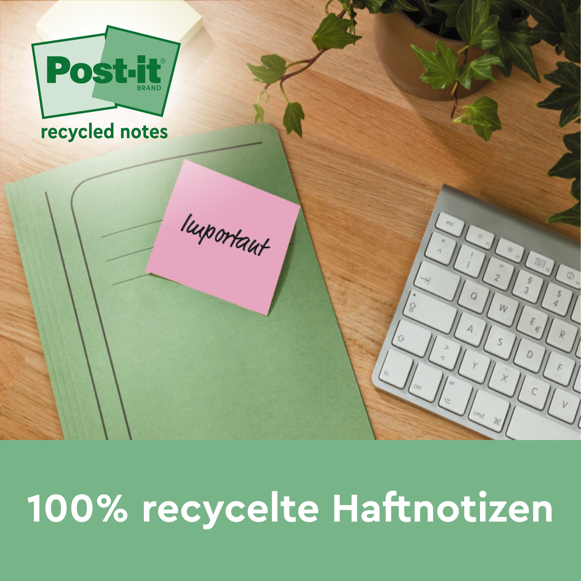 Ein pinkfarbener Post-it® Recycling-Zettel (76 x 76 mm, 100 Blatt, 100% PEFC) der 3M Deutschland GmbH mit der Aufschrift "wichtig" ist an einem grünen Ordner auf einem Schreibtisch neben einer Tastatur und einer Pflanze befestigt. Text: "100% recycelte Haftnotizen.