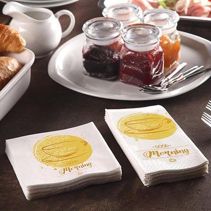 Ένα τραπέζι πρωινού με κρουασάν, μια καράφα και 200 PAPSTAR χαρτοπετσέτες (3-στρώσεων 1/4-πτυχή, 24x24 cm) της PAPSTAR GmbH με την επιγραφή «Καλημέρα», μαζί με βάζα μαρμελάδας και τρία πιρούνια για ένα άνετο πρωινό.