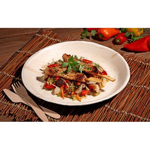 Καλαμάκι με ψητό κρέας με ανάμεικτα λαχανικά και βότανα σερβίρεται σε ένα PAPSTAR 25 πιάτο, από φύλλο φοίνικα "pure" στρογγυλό από την PAPSTAR GmbH, με φιλικά προς το περιβάλλον πιάτα μιας χρήσης και πολύχρωμες πιπεριές και λαχανικά στο φόντο.