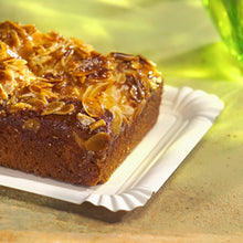 Στο PAPSTAR χάρτινο πιάτο τετράγωνο 13x20 cm, λευκό, "pure" για γιορτές (12 τεμάχια) από την PAPSTAR GmbH ακουμπάει ένα ορθογώνιο κέικ με ξυρισμένα αμύγδαλα - μια φιλική προς το περιβάλλον, κομψή δυνατότητα σερβιρίσματος σε μια φωτεινή επιφάνεια με πράσινο γυαλί πίσω.