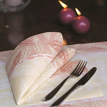 Μια διπλωμένη κόκκινη χαρτοπετσέτα PAPSTAR 50 χαρτοπετσέτες "ROYAL Collection" 1/4-πτυχή 40 x 40 cm από την PAPSTAR GmbH βρίσκεται δίπλα σε πιρούνι και μαχαίρι σε ένα στρωμένο τραπέζι. Στο βάθος φαίνονται δύο αναμμένα μοβ κεριά.