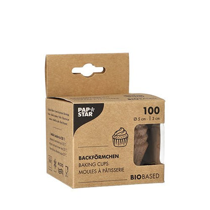 Ένα καφέ κουτί της PAPSTAR GmbH με την επιγραφή «PAPSTAR 100 στρογγυλές φόρμες ψησίματος» περιέχει 100 βιολογικές φόρμες ψησίματος (5 x 3 cm). Η μπροστινή πλευρά δείχνει μια εικονογράφηση cupcake, το τριγλωσσικό όνομα του προϊόντος και ένα παράθυρο που δείχνει τις φόρμες που περιέχονται μέσα.