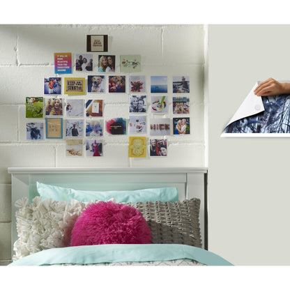 Ein weißes Bett mit tealfarbener und weißer Bettwäsche steht vor einer weißen Backsteinwand. Darüber sind kleine Fotos in einem Raster mit Scotch-FIX™ Ablösbare Klebepads 301008C36-P von 3M Deutschland GmbH angeordnet - starker Halt, leichtes Entfernen.