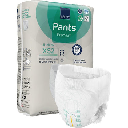 Ένα πακέτο ABENA Pants Junior Premium, Μέγεθος XS2 από την Abena Re-Seller GmbH εμφανίζεται με μια ανοιγμένη πάνα στο προσκήνιο. Η μπεζ συσκευασία με πράσινες και μπλε πινελιές περιέχει 18 κομμάτια X-small.