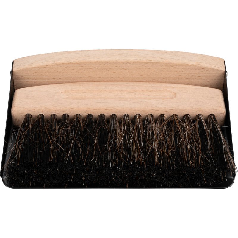 Ένα φαράσι με ξύλινη λαβή και σκούρες τρίχες βρίσκεται σε μια μαύρη σκούπα - ιδανικό όπως το ENA Living Tischkehrset από την Abena Re-Seller GmbH (24er-Karton) για εύκολο καθαρισμό τραπεζιού.