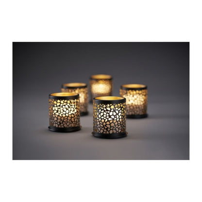 Acht farbenfrohe Duni GmbH Multicolour LED Mini Kerzen leuchten durch gitterförmige Kerzenhalter und werfen zauberhafte Schatten auf eine schlichte Oberfläche für kreative Beleuchtung in einem schummrigen Ambiente.