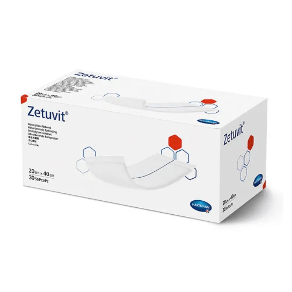 Ένα κουτί Hartmann Zetuvit® απορροφητικές κομπρέσες, κυρίως λευκό με κόκκινα και μπλε σχεδιαστικά στοιχεία. Στο κουτί εμφανίζονται το όνομα του προϊόντος και οι διαστάσεις (20 cm x 40) της Paul Hartmann AG.