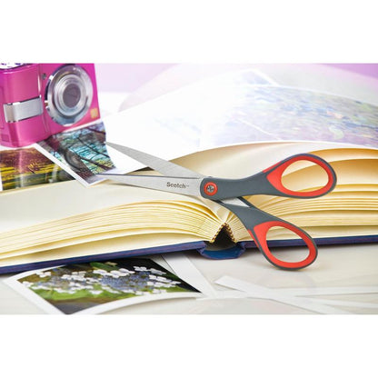 Το κόκκινο ψαλίδι ακρίβειας Scotch™ από την 3M Deutschland GmbH βρίσκεται σε ένα ανοιχτό άλμπουμ φωτογραφιών με φωτογραφίες. Στο τραπέζι υπάρχουν επίσης μια ροζ κάμερα και χαλαρές φωτογραφίες.