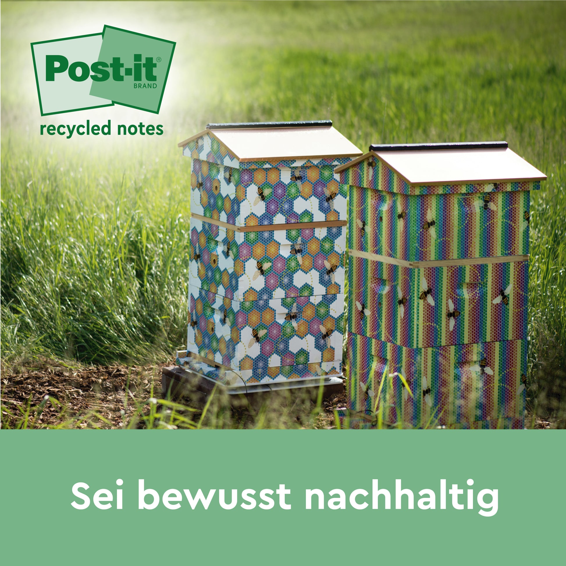 Zwei bunte Holzbienenstöcke stehen auf einer Wiese. Oben links das Logo der 3M Deutschland GmbH und "Post-it® Recycling Notes, 100% PEFC". Am unteren Rand steht der Text "Sei bewusst nachhaltig".