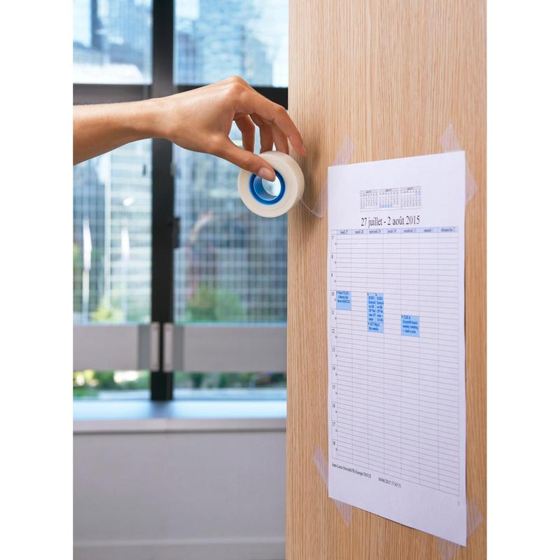 Ένα χέρι χρησιμοποιεί μια αόρατη ταινία Scotch® (19 mm x 33 m) από την 3M Deutschland GmbH για να στερεώσει ένα τυπωμένο σχέδιο σε έναν φωτεινό ξύλινο τοίχο. Στο φόντο, το παράθυρο δείχνει την αστική θέα της πόλης.