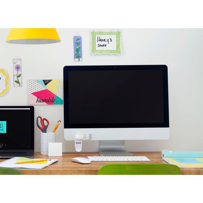 Ένα τακτοποιημένο γραφείο με μια μεγάλη οθόνη, ένα κλειστό φορητό υπολογιστή, μια κούπα με στυλό και ψαλίδια, είδη γραφείου και τον διανομέα ταινίας 3M Scotch™ Clip & Twist C19 με αόρατη ταινία Magic™ στην οθόνη. Στον τοίχο υπάρχουν διακοσμητικές σημειώσεις όπως "Τα πράγματα του Henry".