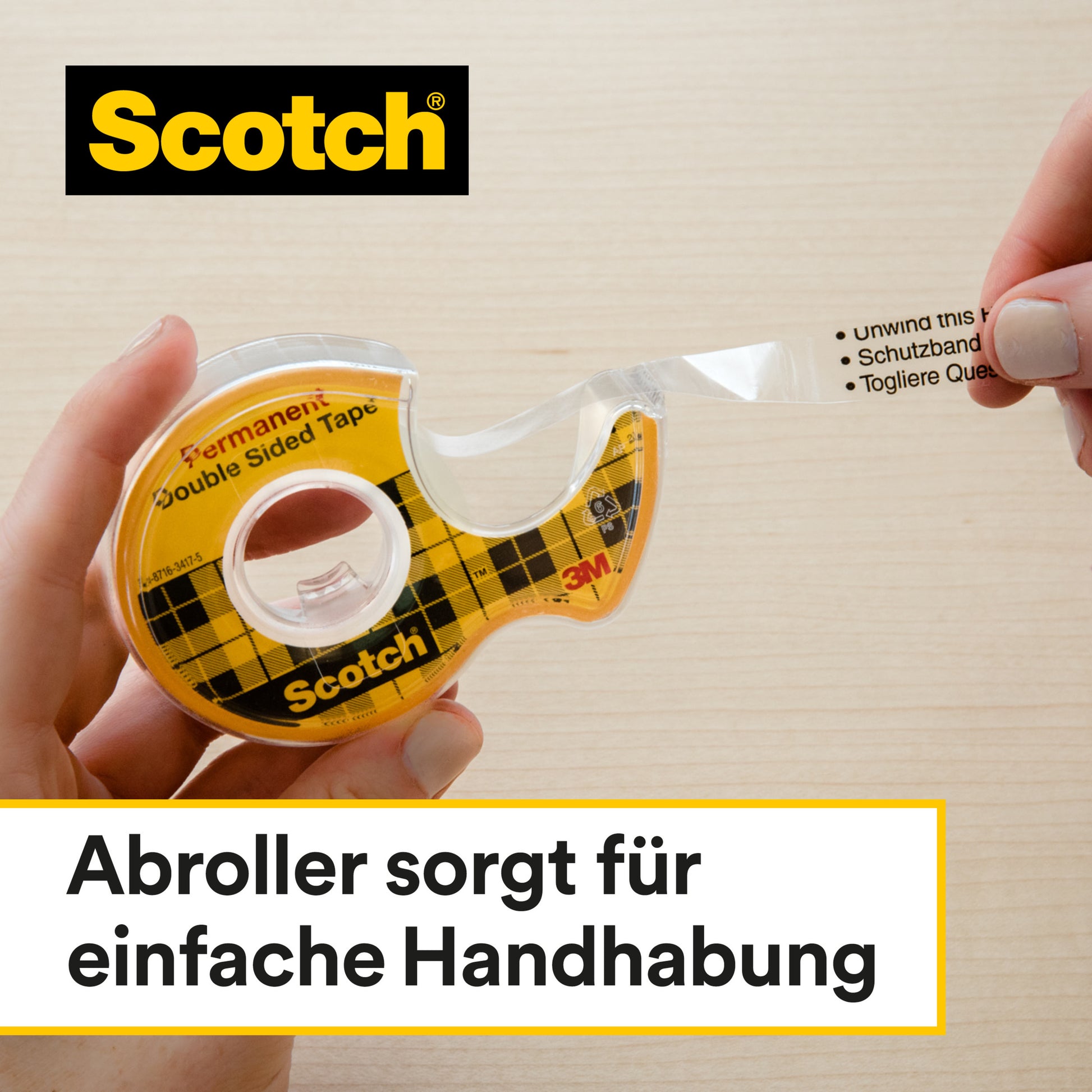 Eine Hand zieht das Scotch® doppelseitige Klebeband Nachfüllpackung (2 Rollen, 12 mm x 6,3 m) von 3M Deutschland GmbH aus dem Abroller auf eine Holzfläche. Der Text unten auf Deutsch: "Abroller sorgt für einfache Handhabung.