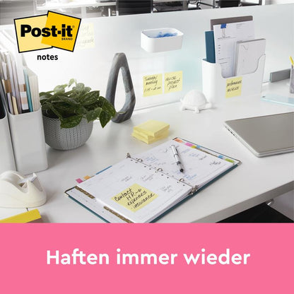 Ένα τακτοποιημένο γραφείο δείχνει Post-it® Notes, Κίτρινο, 38 mm × 51 mm (100 φύλλα/μπλοκ, 12 μπλοκ/συσκευασία, 100% PEFC) από την 3M Deutschland GmbH. Οι σημειώσεις είναι ορατές στο γραφείο και στο διαχωριστικό. Το κείμενο από κάτω λέει: "Κολλάνε ξανά και ξανά.